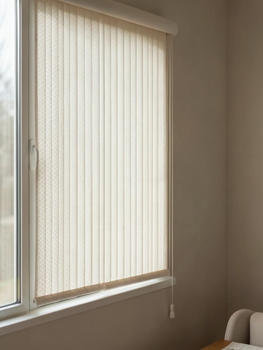 Store plissé en tissu ivoire tendu sur une fenêtre